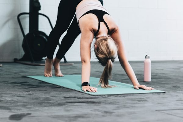 woman in black sports bra and blue denim jeans doing yoga